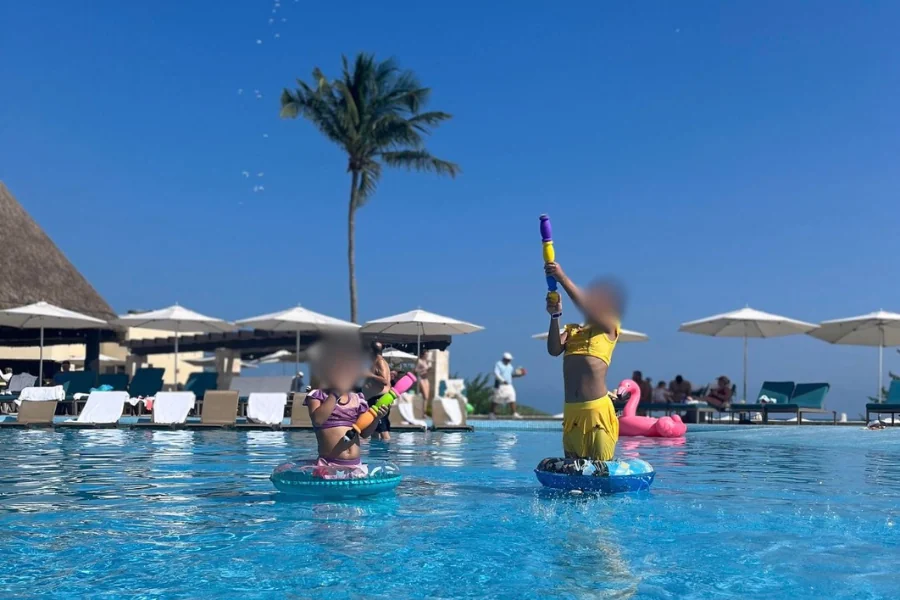 ムーンパレスカンクンのプールで、浮き輪に乗って水鉄砲で遊ぶ子供2人